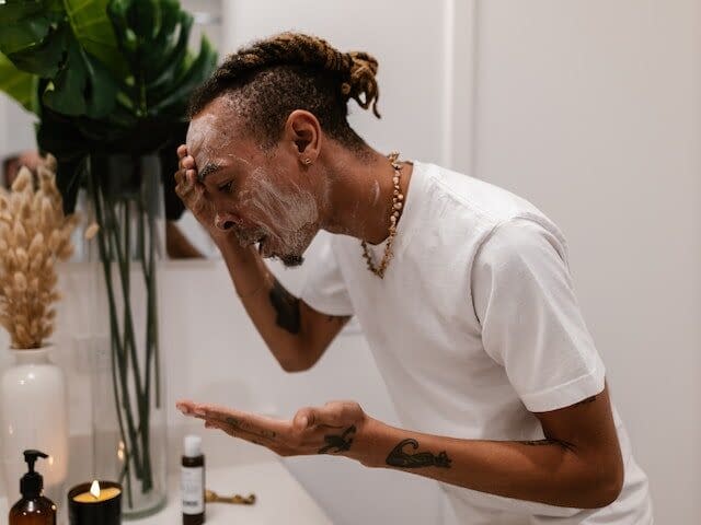 a man cleansing his face with foam