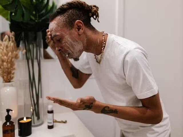 a man is scrubbing his face with soap foam