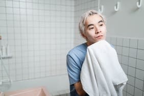 man pat drying his face with towel