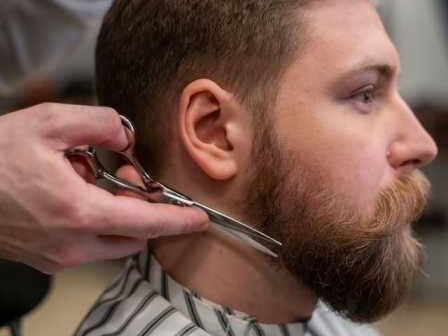 barber trimming clients beard split-ends